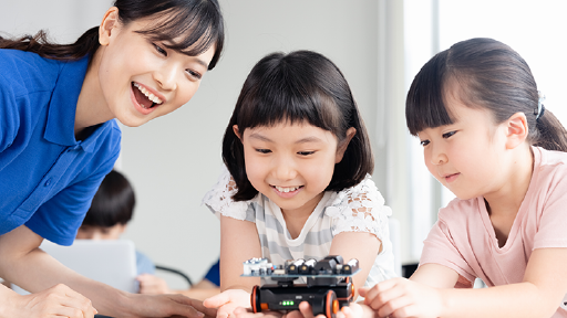 機械を触る子供と見守る大人